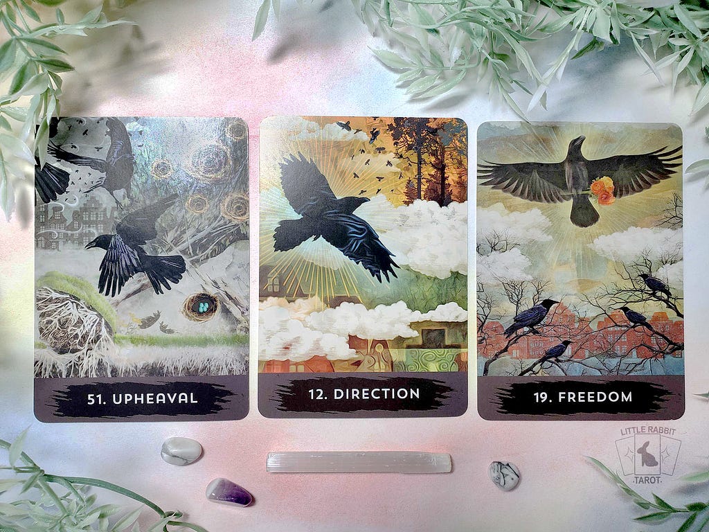 A photo of three cards from the Urban Crow Oracle deck: Upheaval, Direction, and Freedom.