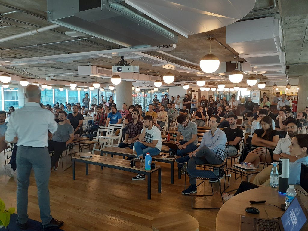 Almundo’s team seated listening to the CEO standing at the front