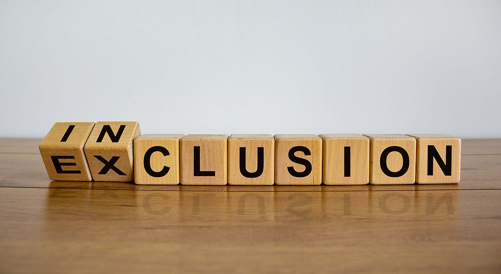 Symbol for better inclusion. Inverted cube and changed word exclusion to inclusion. Beautiful wooden table, white background