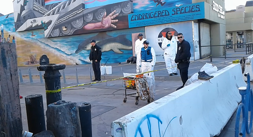 LAPD officers and LA Sanitation workers during a sweep on the boardwalk at Venice Beach, CA