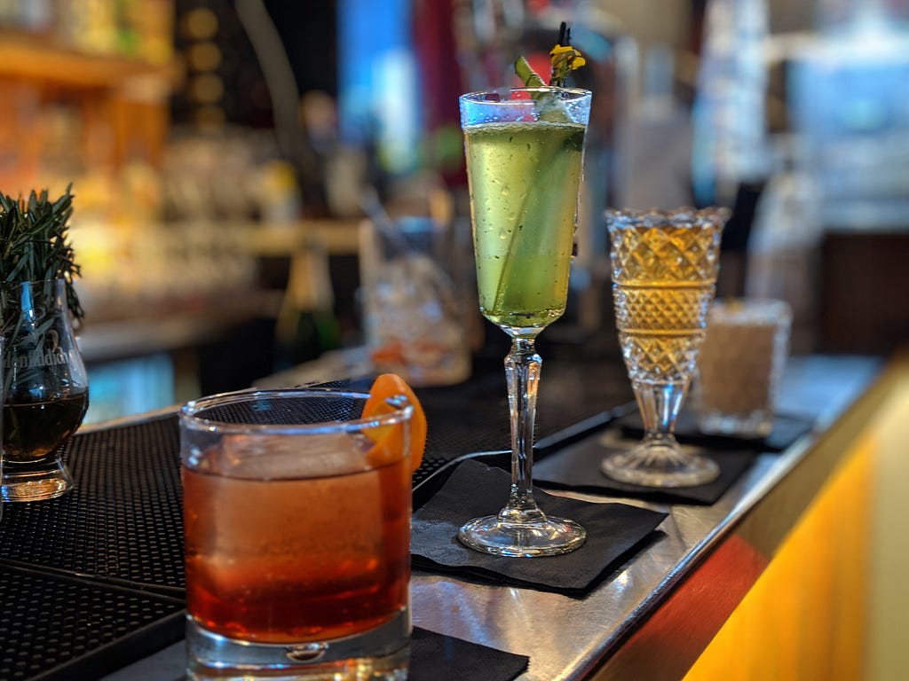 Four delicious AI-generated cocktails placed on a bar.