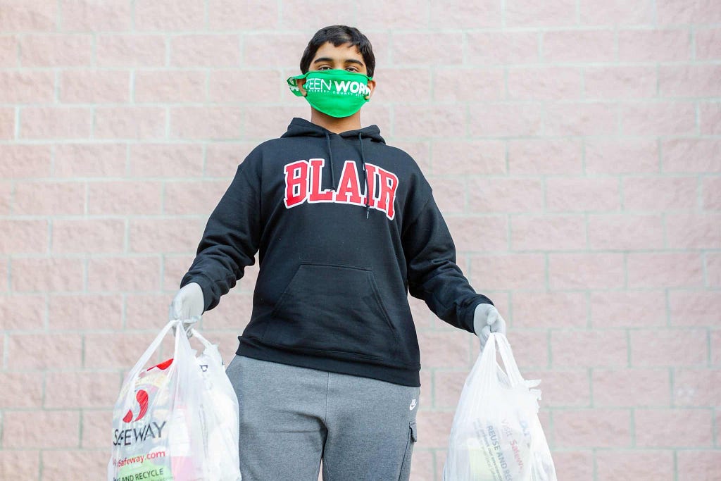 Druv wearing a mask and gloves, holding two grocery bags