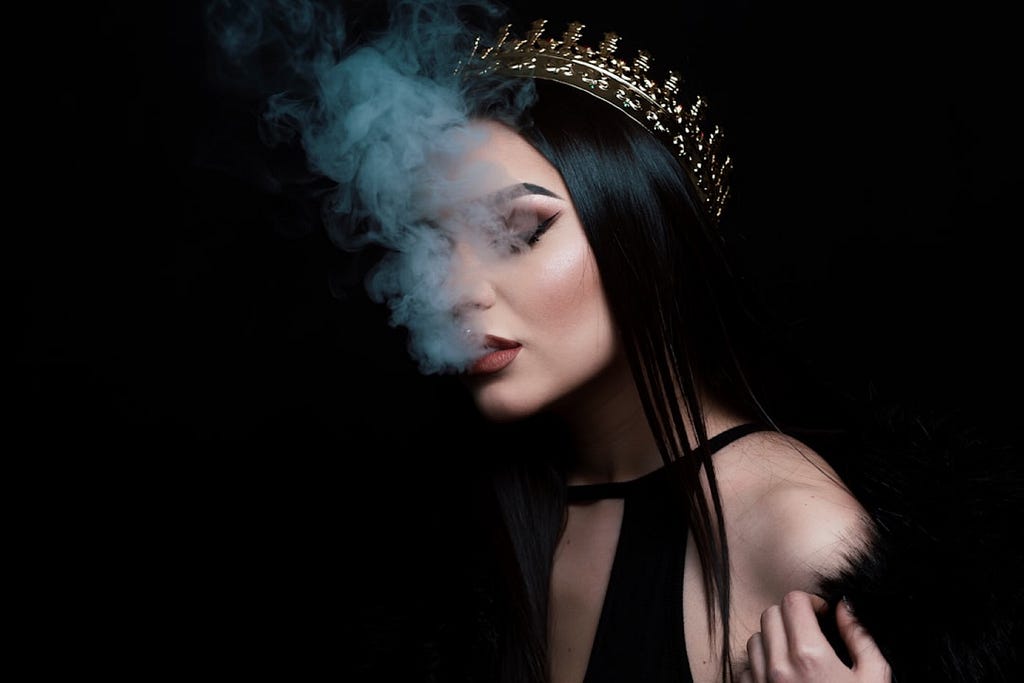 Alex Mihai C took this photo of a goth woman in the foreground of a black background with Hookah smoke rising from her mouth.