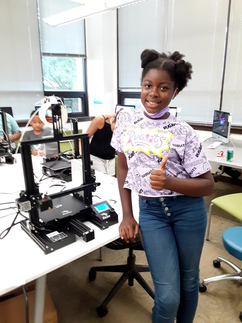 Student stands with a thumbs-up pose next to their personal Ender 3 Pro 3D printer at the Funbotics 3D Modeling and Printing Camp in July of 2021.