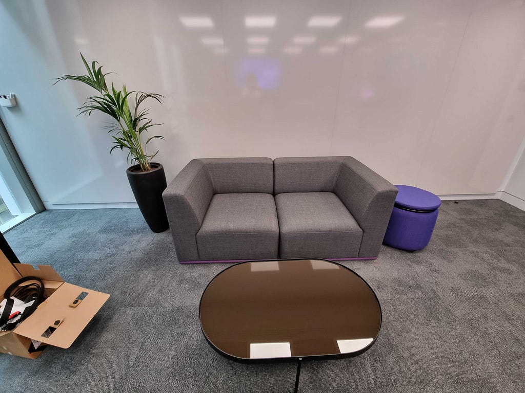 An empty living room soft, with a coffee table and large plant is set up ready for users to sit and test BT products comfortably.