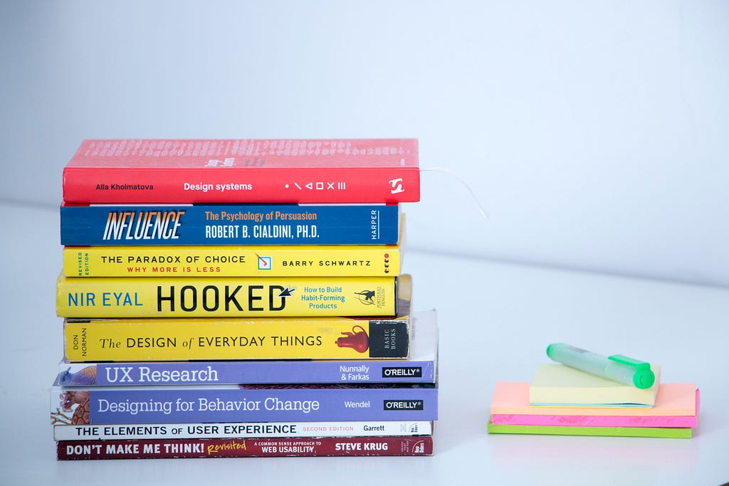 Stack of books on user research and design