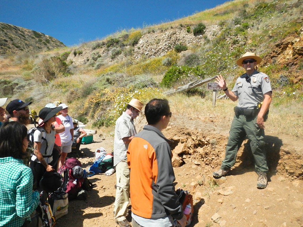 Ranger Dustin Waters gives newly arrived campers and hikers on California’s Santa Cruz Island information about safety and protection of animals such as island foxes and ravens in Channel Islands National Park. (copyright April Orcutt — all rights reserved)