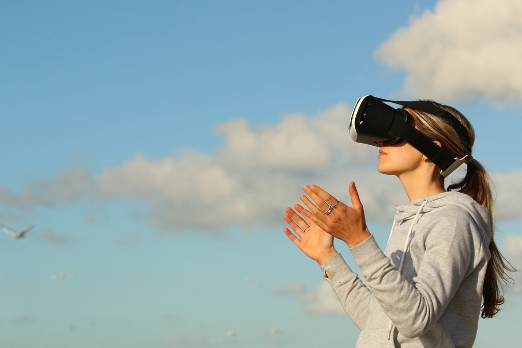 Woman using VR goggles outdoors.