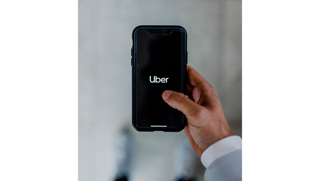Person holding a phone with the Uber app loaded on it
