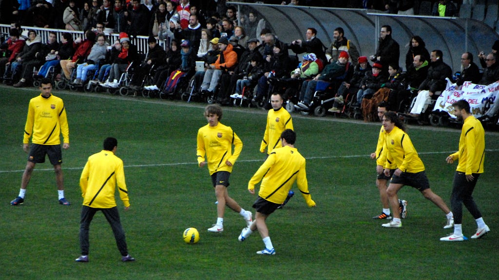 Barcelona players in yellow training tops warming up in a rondo