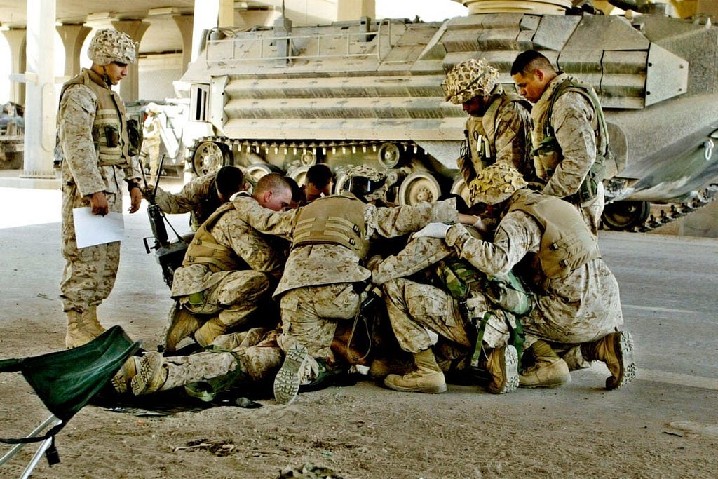 Soldiers praying for a fallen comrade