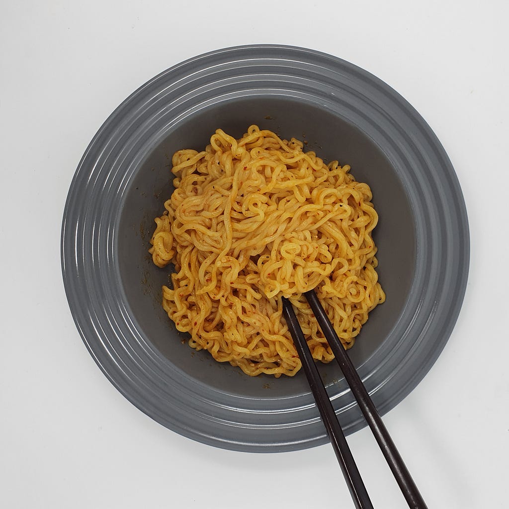 A finished bowl of Wicked Ramen (Yogoe Ramyeon) Itaeweon Chamggae Majemat in a bowl with chopsticks.