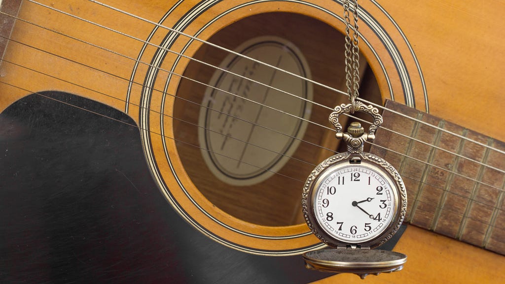 Acoustic guitar and cool old fashioned pocket watch