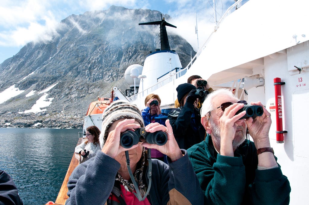 Adventure Canada’s guests on board the Sea Adventurer watch the first of several polar bears sighted on the trip walk across sea ice in Labrador in northeastern Canada.