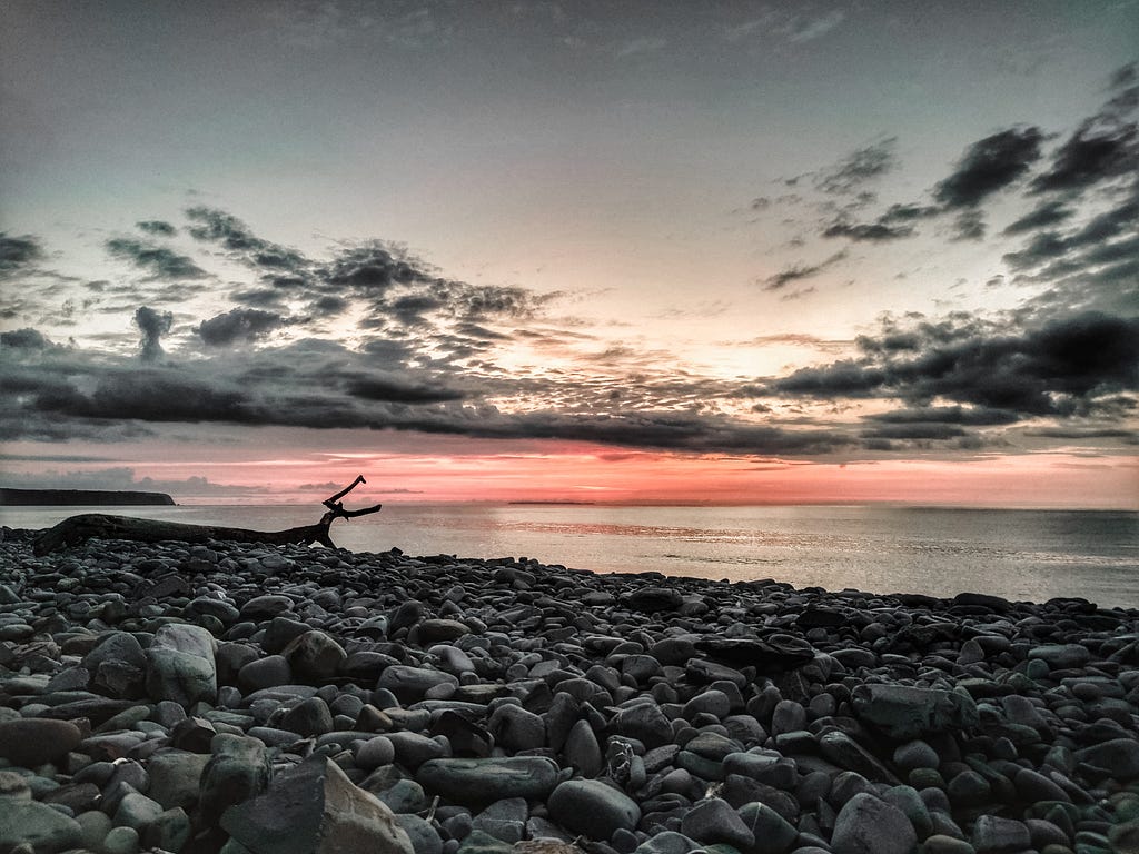 Sunset on secluded rocky beach