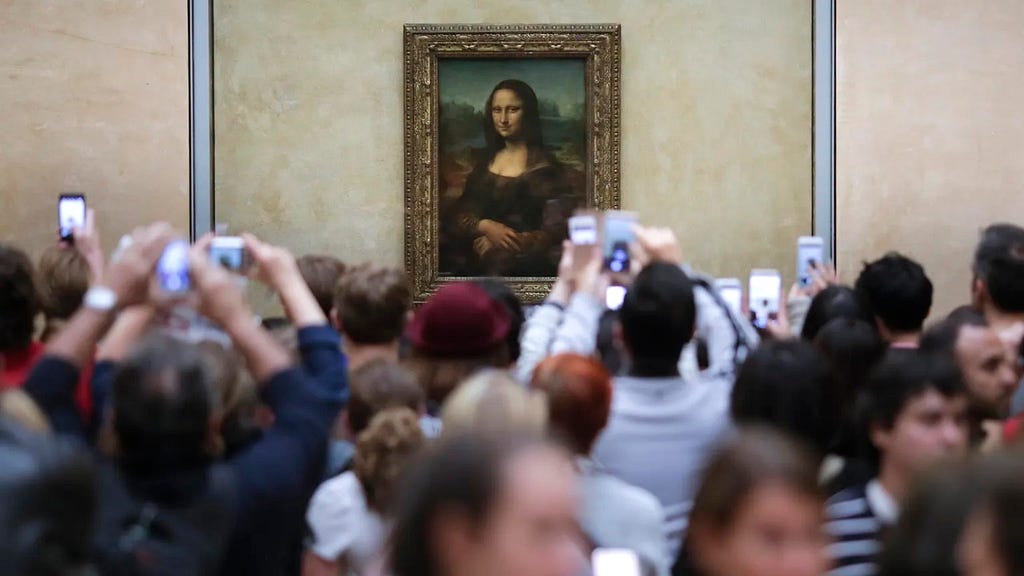 Visitors crowd in front of Leonardo da Vinci’s painting Mona Lisa at The Louvre in Paris.
