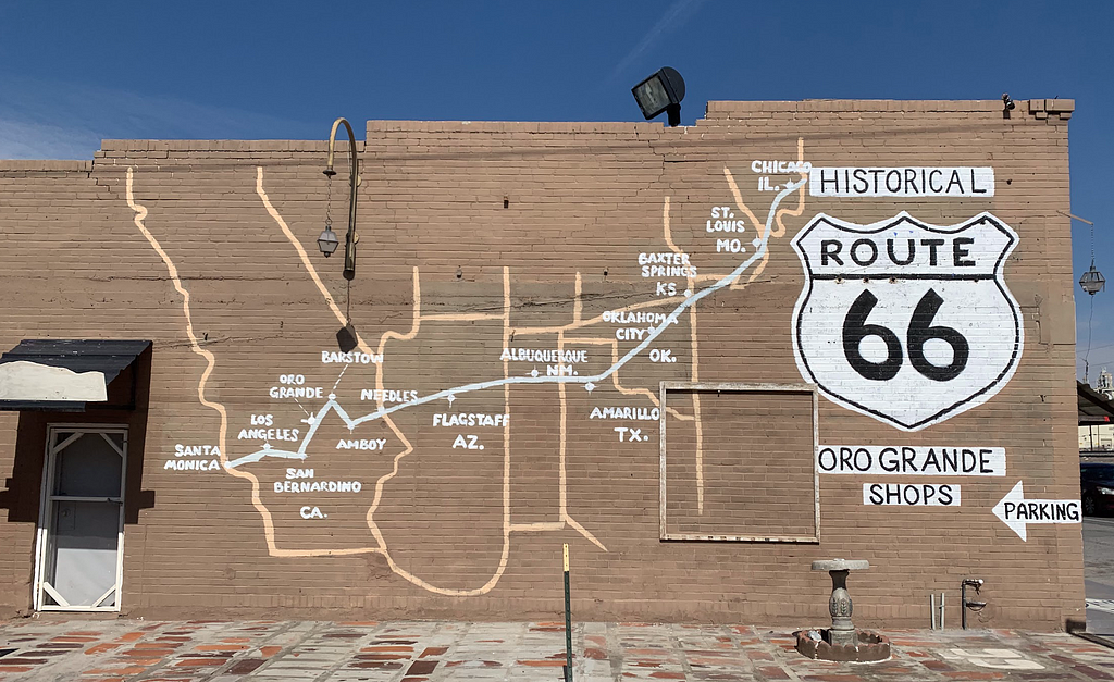 Side of a brick building with a map of historic route 66 across drawn