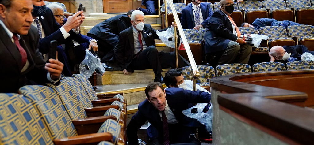 Photo in US Chamber. Representatives, staffers and observers shelter in place in the House gallery as rioters try to break into the chamber January 6, 2021