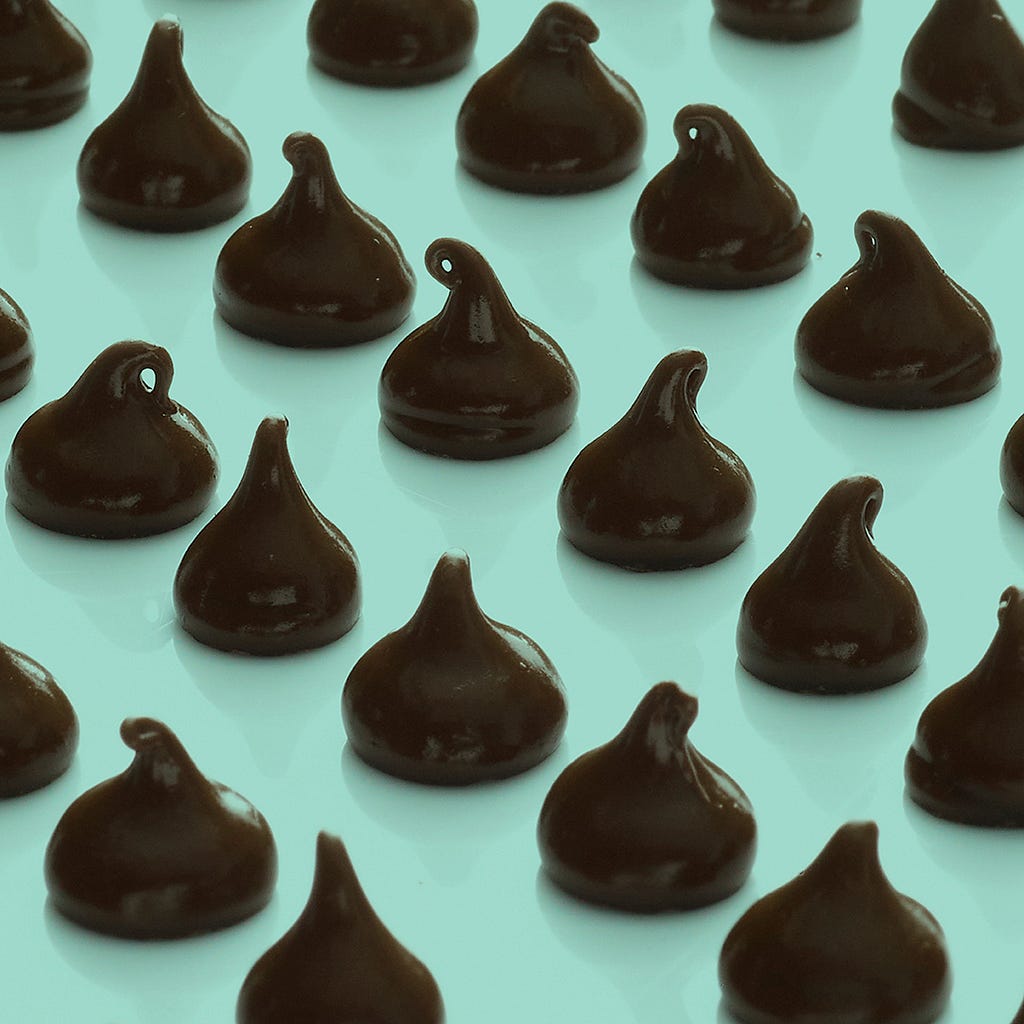 Chocolate chips arranged in rows on a green background