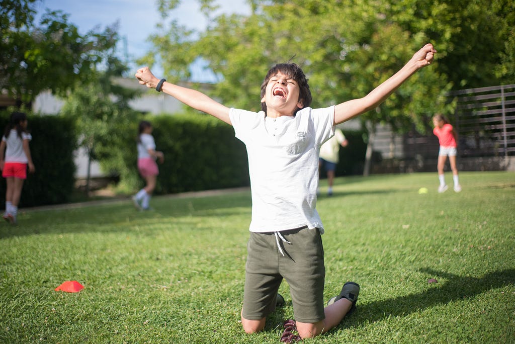 A boy is celebrating the winning moment of his success on the ground.