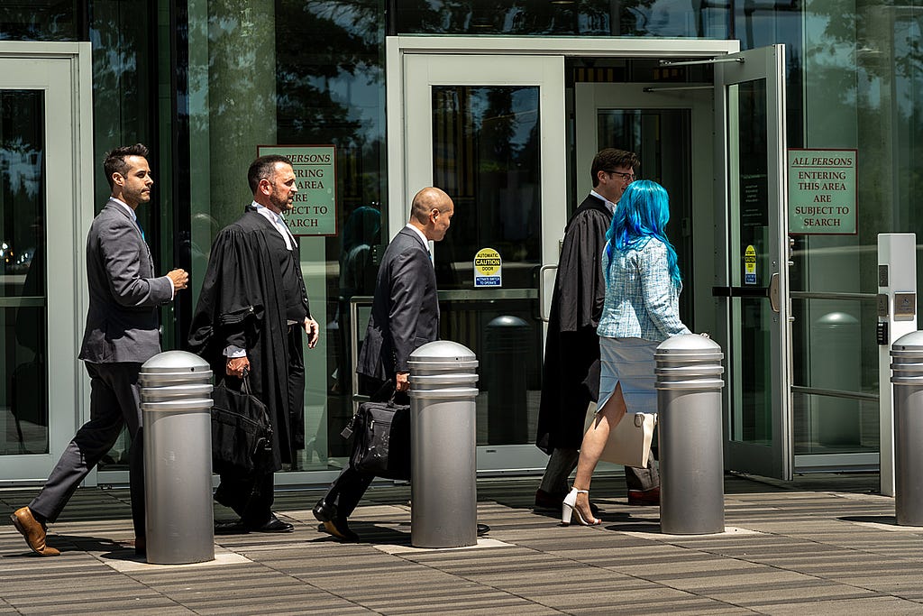 Activists Nick Schafer, Roy Sasano, and Amy Soranno leave the courthouse with two of their three lawyers, Joe Killoran and Leo Salloum, during the lunch break of their trial in Abbotsford, British Columbia. Canada, 2022. Suzanne Goodwin / We Animals Media