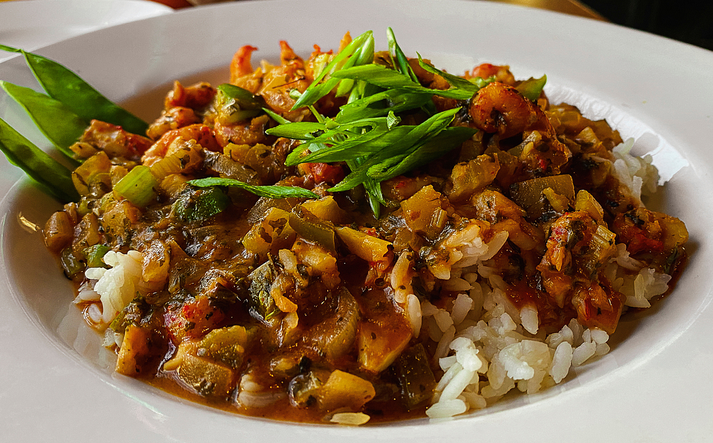 Bowl of Crawfish Étouffée on white rice with green garnish.