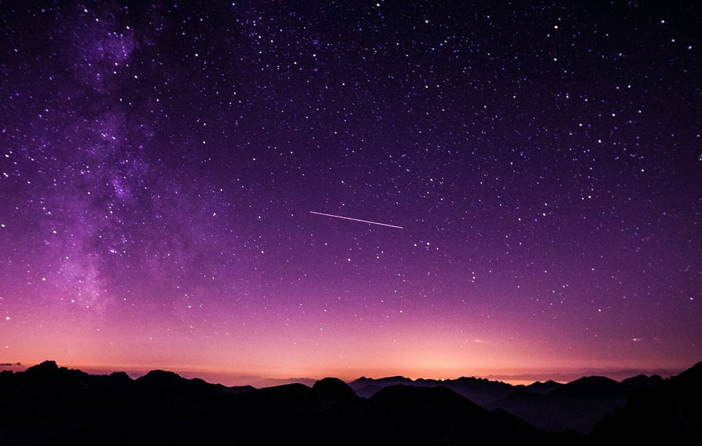 Image of a star filled sky, with a view of the mountains.