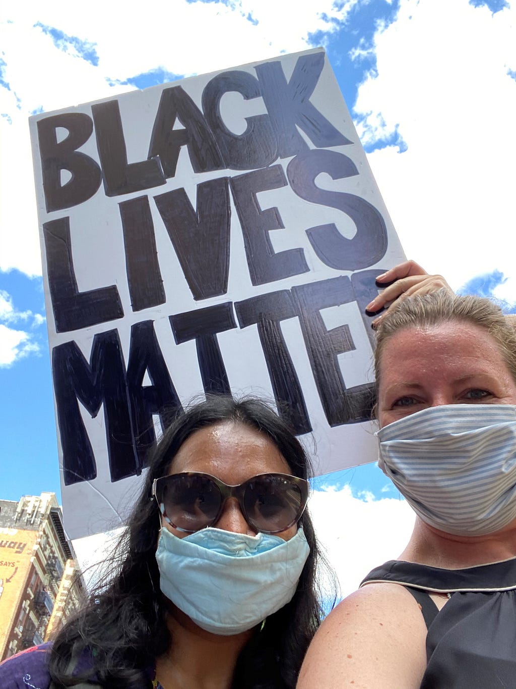 Adél Grobler, right, posing with a Black Lives Matter sign