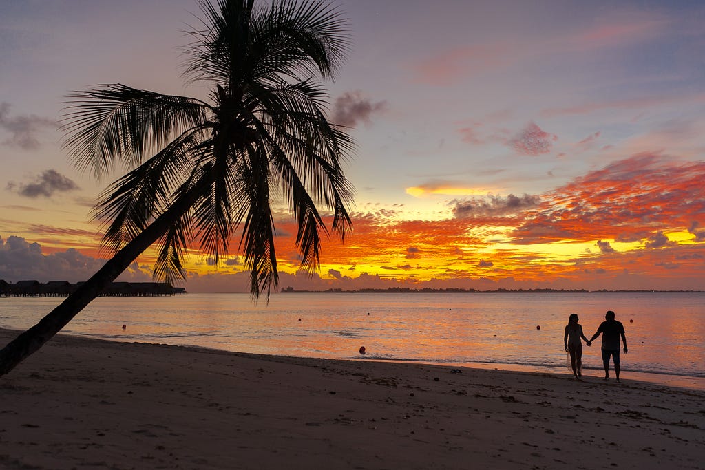 A couple on the beach during a sunset