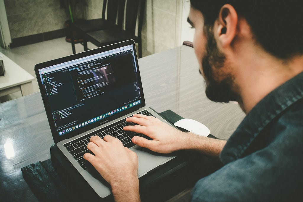 A man programming on a laptop