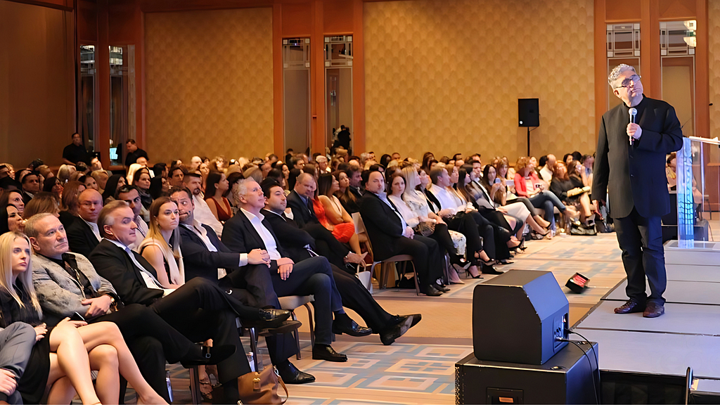 Renowned international motivational speaker Deepak Chopra, addressing a large and diverse audience in India about the mind-body connection and holistic well-being.