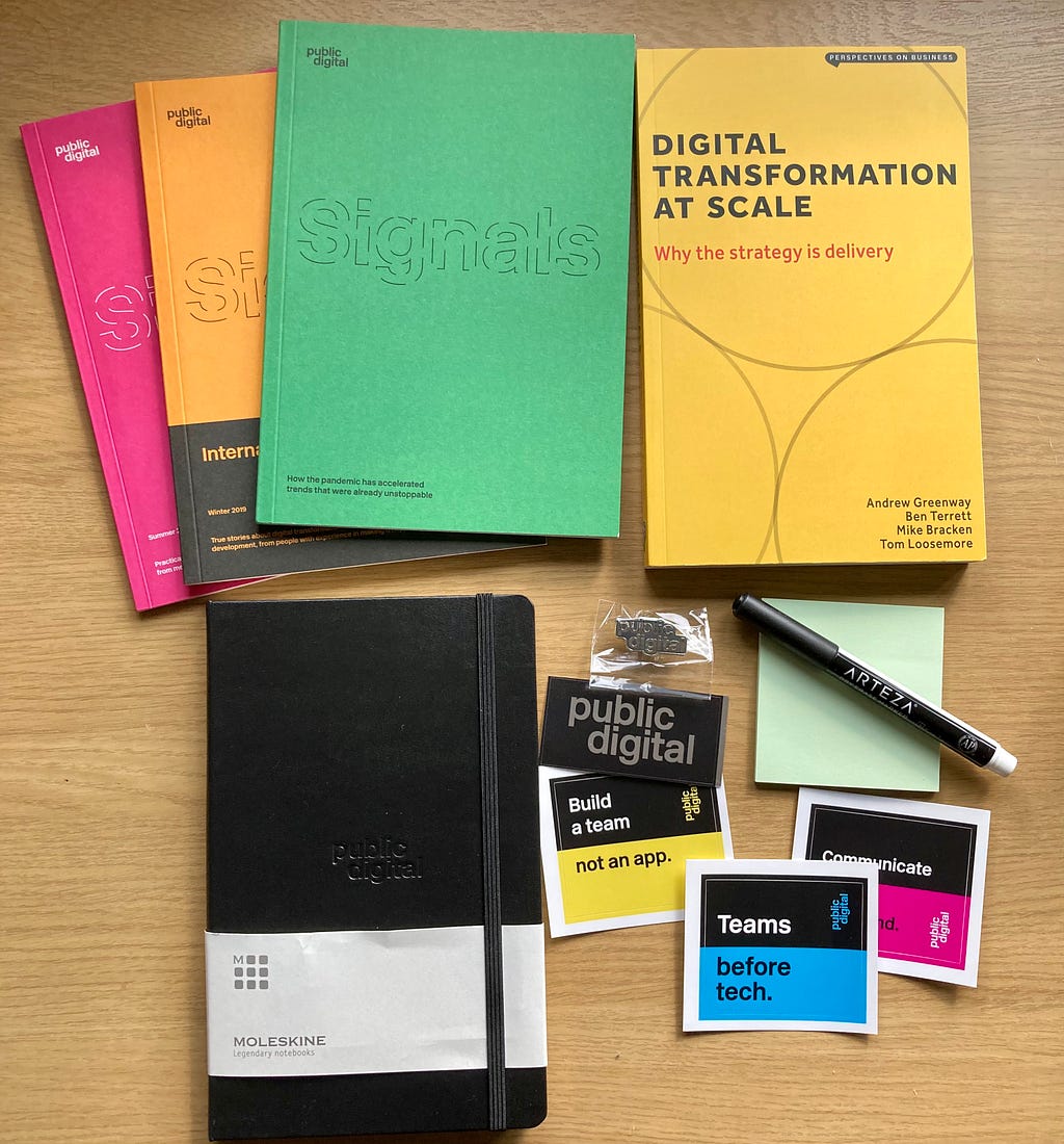 A selection of goodies from joining Public Digital (notebooks, books, stickers, badges, stationery)
