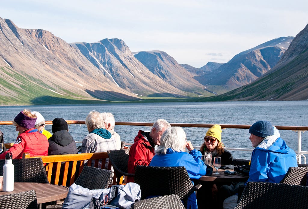 Adventure Canada’s guests enjoy a barbecue on the back deck of the Sea Adventurer in a fjord in Torngat Mountains National Park in northern Labrador in eastern Canada.