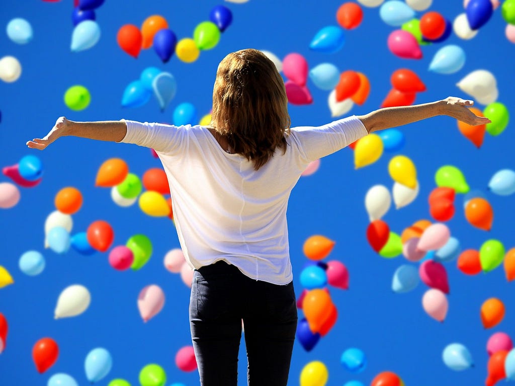 say yes to being happy and joyful, woman with outstretched arms and balloons