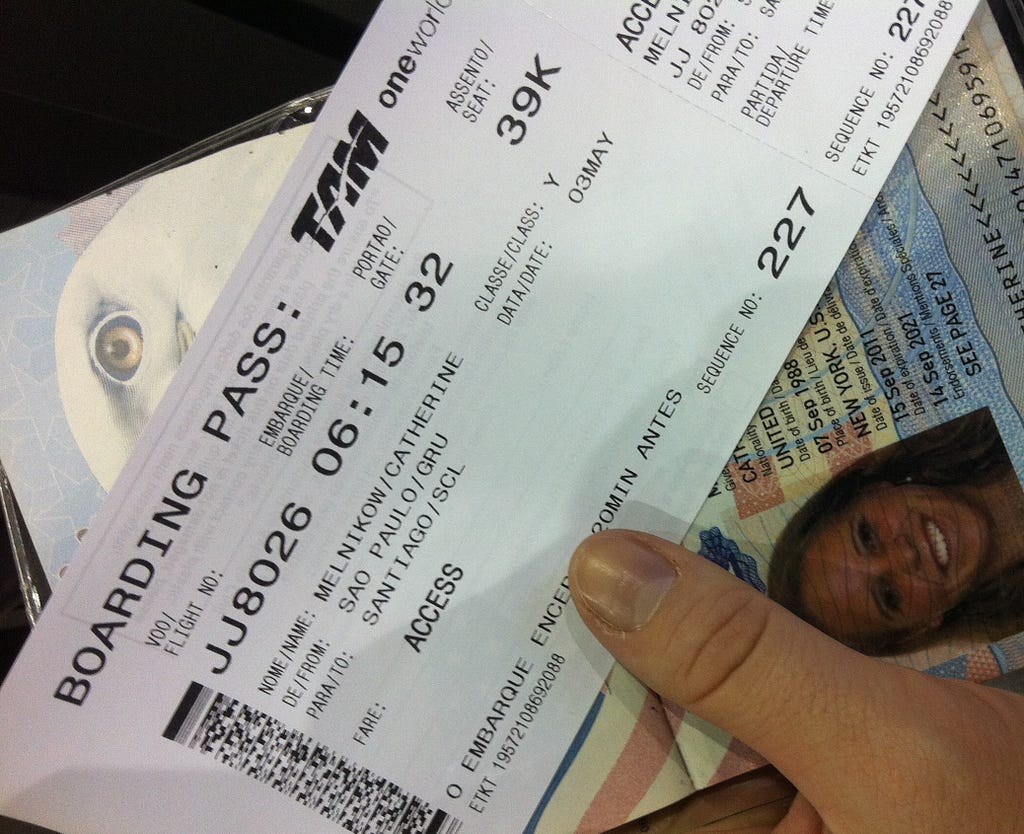 A ticket and passport held in hand