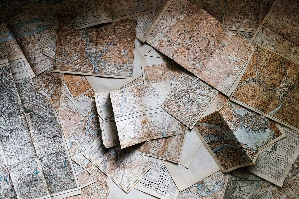 A collection of randomly thrown maps on a table