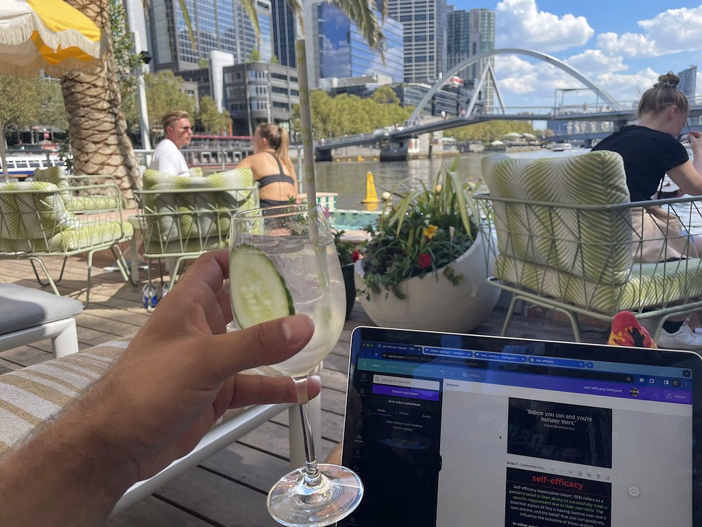 Working from a bar on a boat, with a cocktail in my hand in front of my laptop