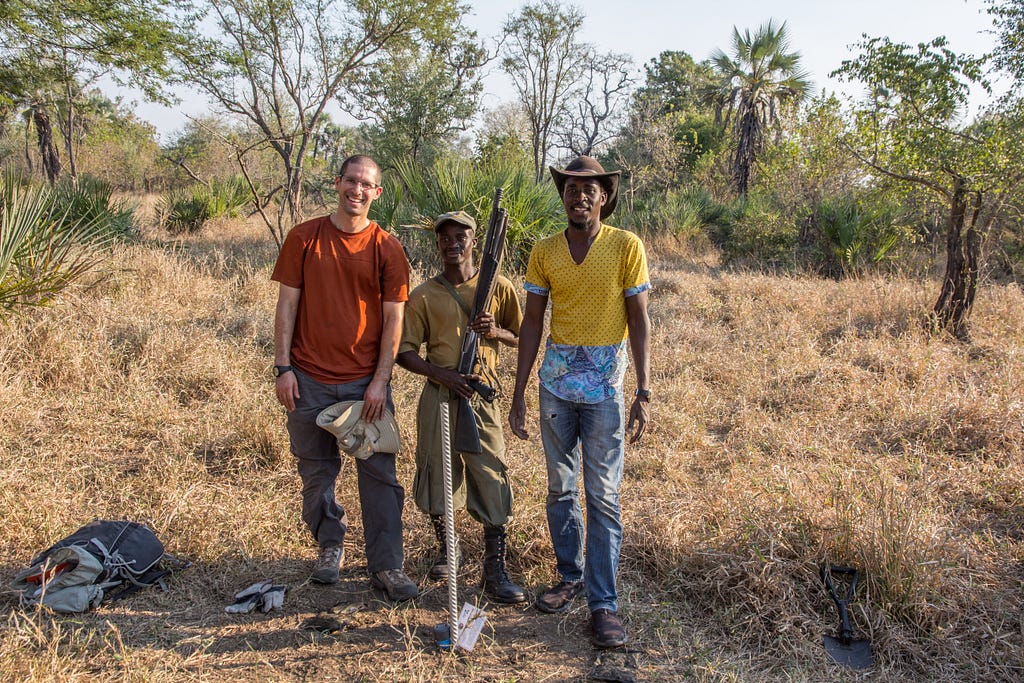 Josh Daskin with his then field assistant, Mateus Dapitaia and park guard, Ernesto, installing flood level sensors in Gorongosa National Park.