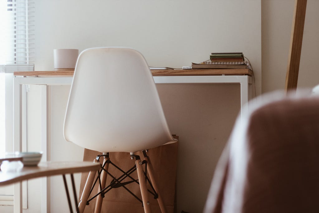 A chair standing in front of a desk.