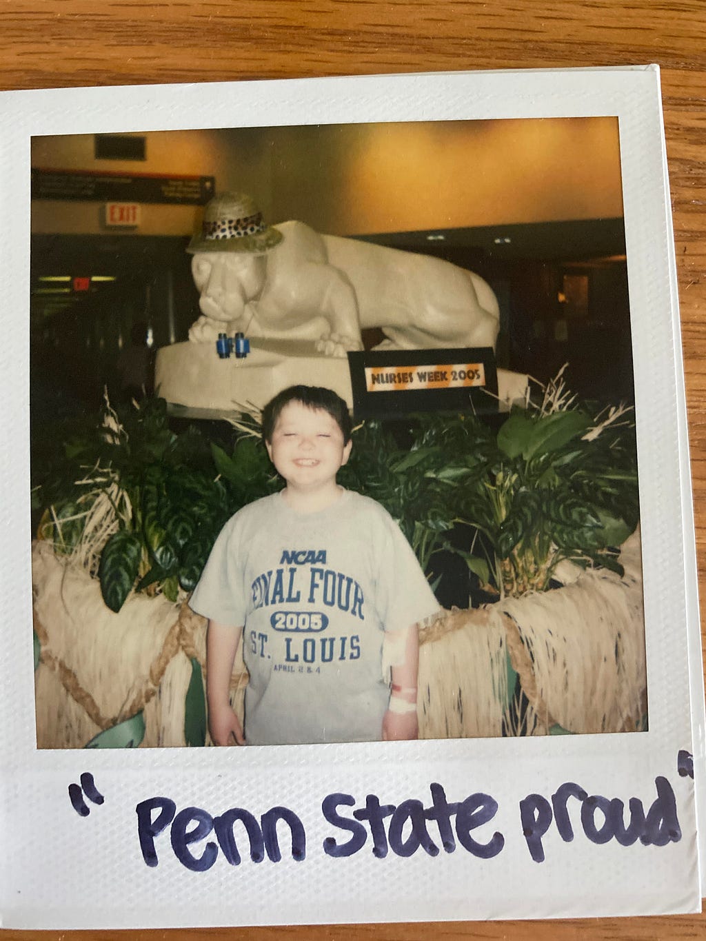 A young boy smiling with a Final Four St. Louis t-shirt on.