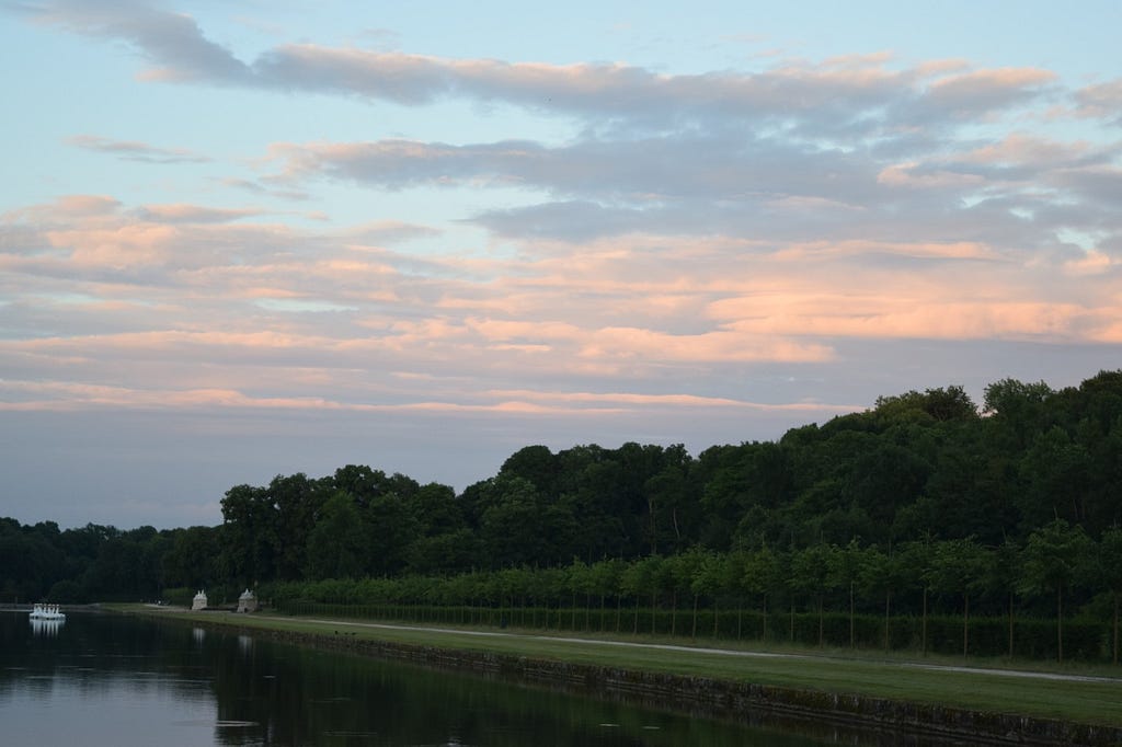 Swan boats floating under cotton-candy skies just outside the Château de Vaux-le-Vicomte.