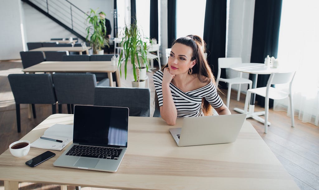 young attractive woman is sitting at the table planning to form a company