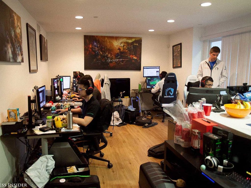 An image of a room filled with computer set-ups and Team Liquid members.