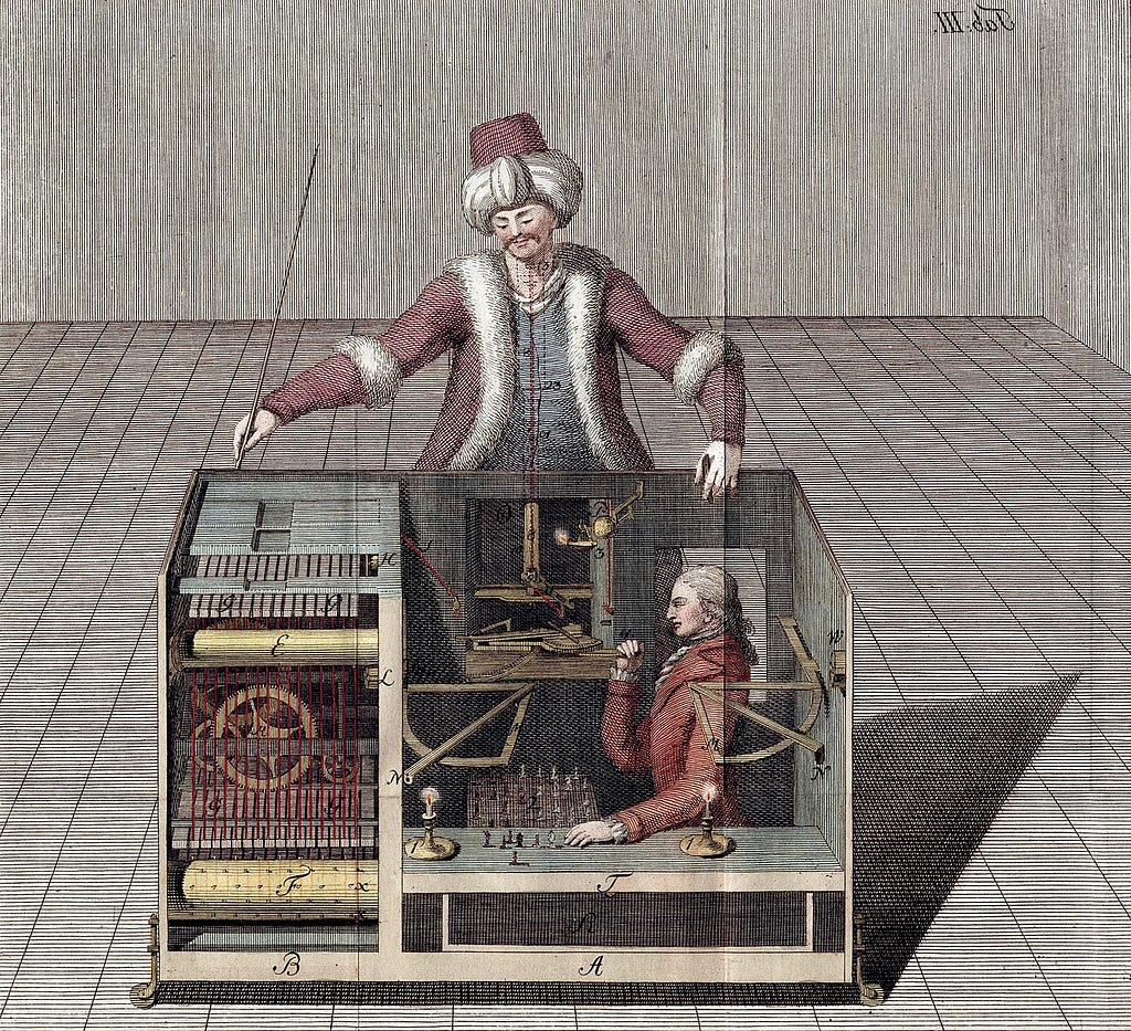 A man stands on top of a complex machine. We look inside it and there is a small man pullings strings to move chess pieces above