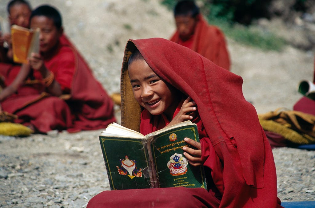 Child reading Tibetan Buddhist text.
