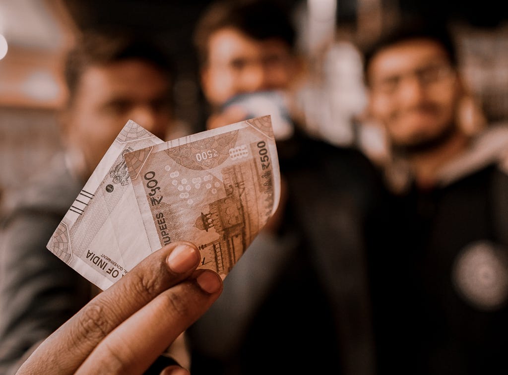 A man forwarding an Indian 500 rupee note