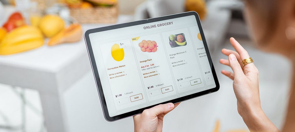 Women doing online grocery shopping by on a tablet in her kitchen