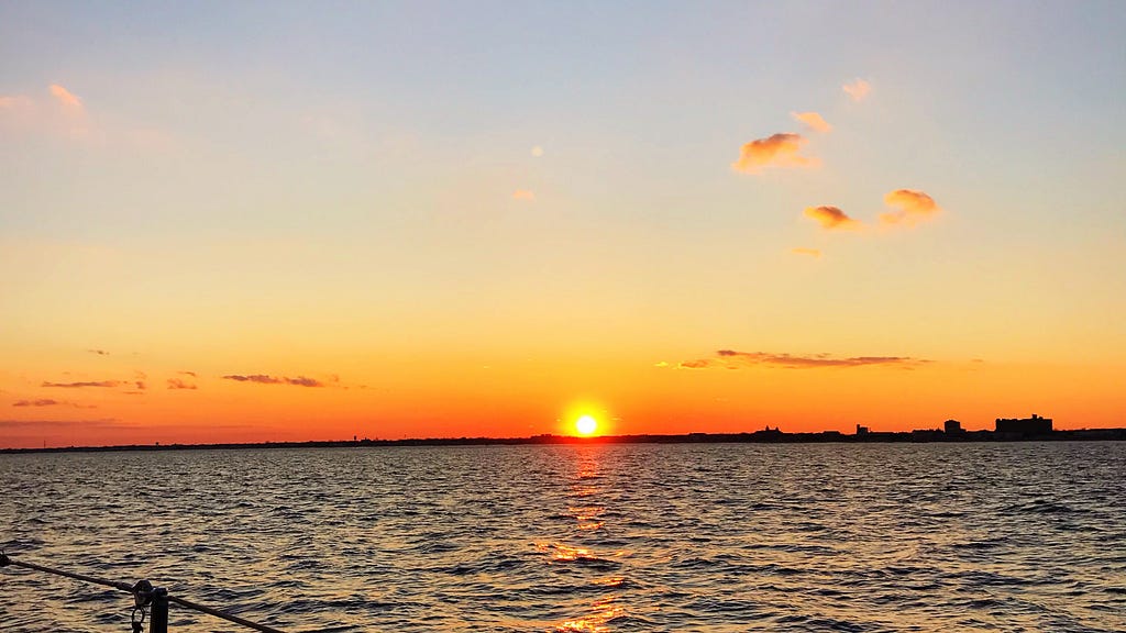 A sunset off the coast of New Jersey from the water.