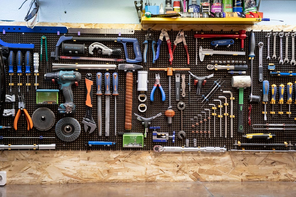 Colorful hand tools organized on a vertical pegboard