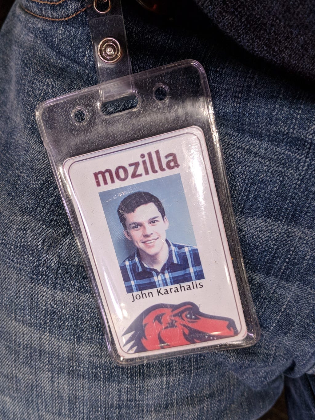 The employee badge for John Karahalis resting against his jeans